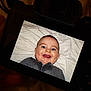 Marius participe au concours pour gagner de l'argent avec cette photo : baby, infant, child, smiling, face, blue_eyes, dimple, teeth, blanket, bedding, sweater, zipper, portrait, closeup, camera_screen, camera, electronics, indoor, cheerful, wrinkles