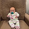 Anslee is registered to the contest to win money with this photo: baby, infant, child, sitting, armchair, pacifier, pajamas, clothing, pink, turquoise, brown, portrait, indoor, furniture, cushion, textile, wide_eyed, adorable, front_view, photograph