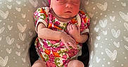 Anslee is registered to the contest to win money with this photo: baby, baby_pillow, blanket, clothing, couch, cozy, cute, floral_onesie, headwear, heart_pattern, indoor, infant, newborn, person, pink_bow, relaxing, resting, sleeping, small_baby, soft_fabric