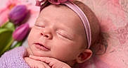 Sophia is registered to the contest to win money with this photo: newborn, baby, sleeping, portrait, face, headband, flower, floral, blanket, lavender, purple, pink, hands, closed_eyes, peaceful, infant, closeup, soft_lighting, bouquet, nursery