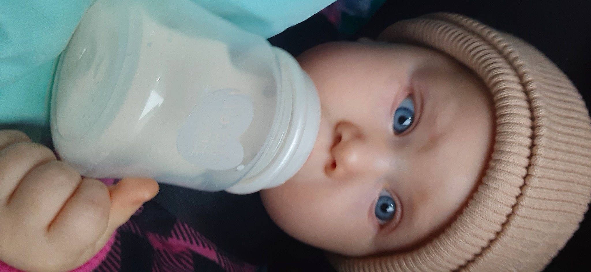 Saige is registered to the contest to win money with this photo: baby, baby_bottle, cap, cheek, child, chin, drinking, drinkware, eye, eyebrow, eyelash, headwear, iris, lip, liquid, mouth, nose, person, plastic, plastic_bottle