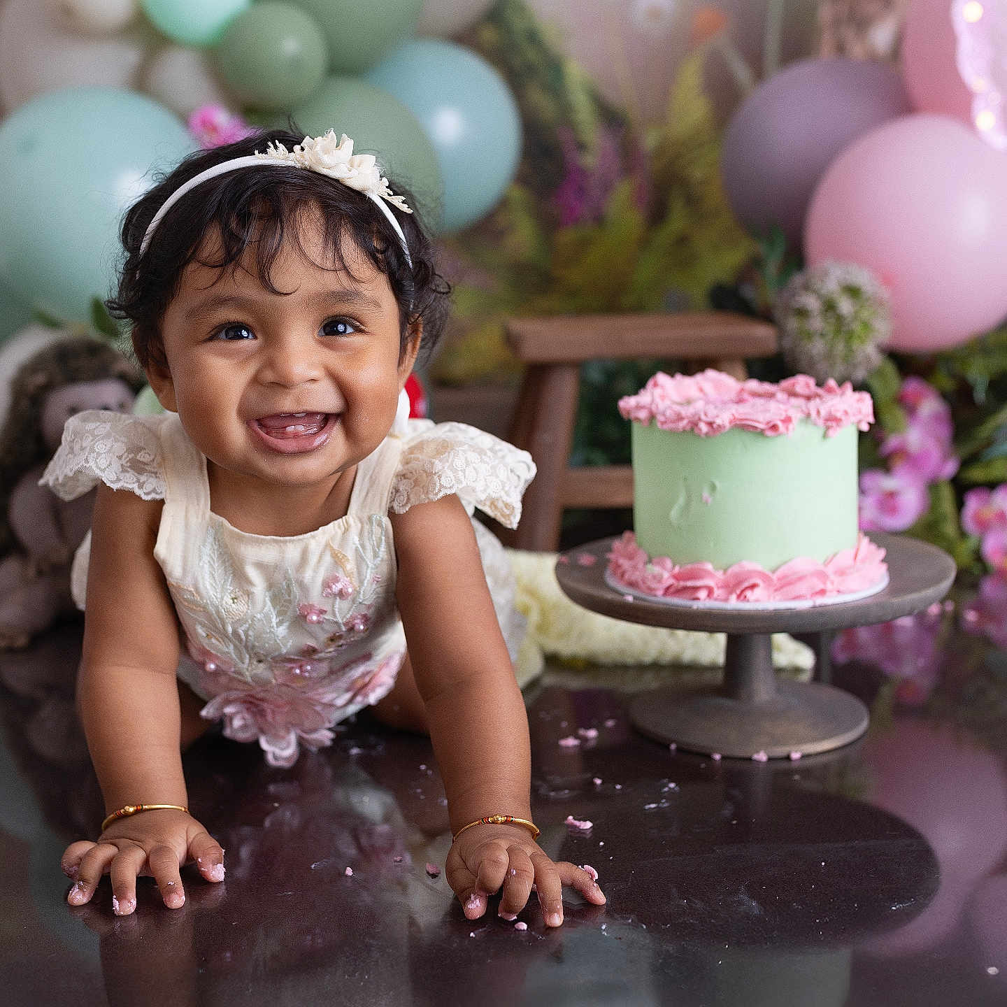 Sanvi is registered to the contest to win money with this photo: accessories, baby, birthdaycake, bodypart, bracelet, cake, cream, dessert, face, finger, flower, flowerarrangement, food, hand, head, icing, jewelry, people, person, plant