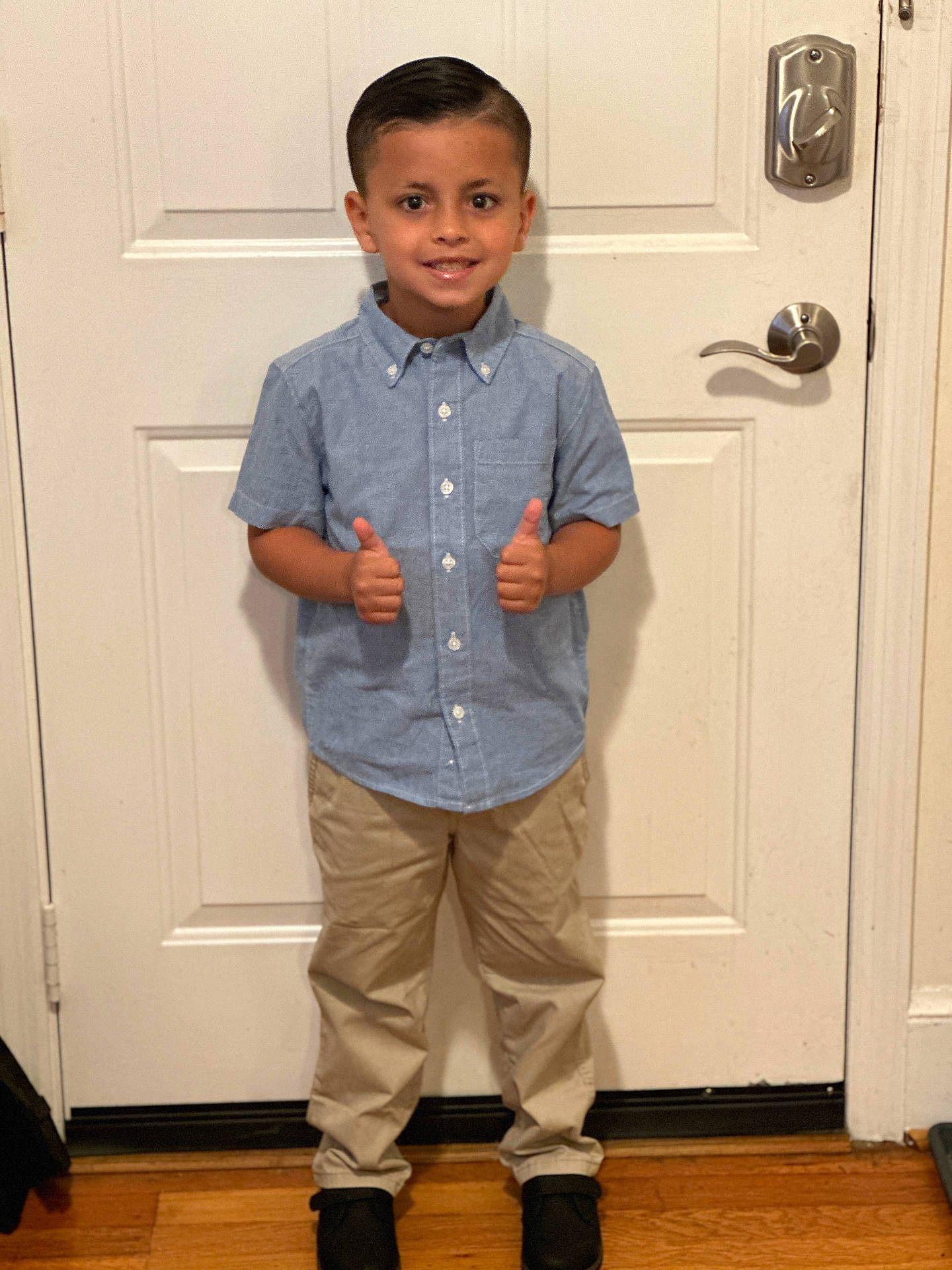 Jaidyn is registered to the contest to win money with this photo: blouse, bodypart, boy, child, clothing, door, face, finger, footwear, hand, hardwood, head, male, pants, person, plywood, shirt, shoe, standing, wood