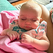 Emery is registered to the contest to win money with this photo: baby, sleeping, blanket, pink, infant, hands, face, closed_eyes, soft_light, home_interior, couch, comfort, peaceful, child, person, portrait, cute, resting, cozy, clothing
