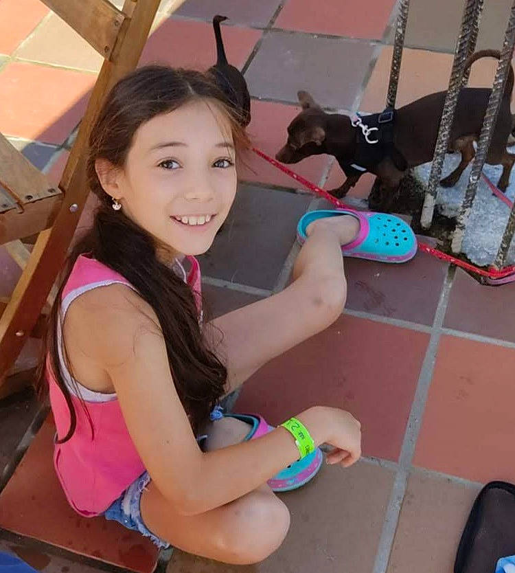 Emma Lou a rejoint le concours — aidez-le/la à gagner de superbes lots ! abdomen, black_hair, child, fashion_accessory, fun, happy, human_leg, joy, leisure, long_hair, pattern, person, pink, recreation, shorts, sitting, skin, smile, t_shirt, thigh