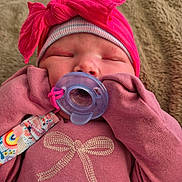 Nevaeh Mccormick is registered to the contest to win money with this photo: baby, pacifier, pink_clothing, hat, bow, sleeping, infant, gloves, blanket, closeup, cute, child, face, apparel, newborn, soft_texture, indoors, resting, baby_girl, cozy