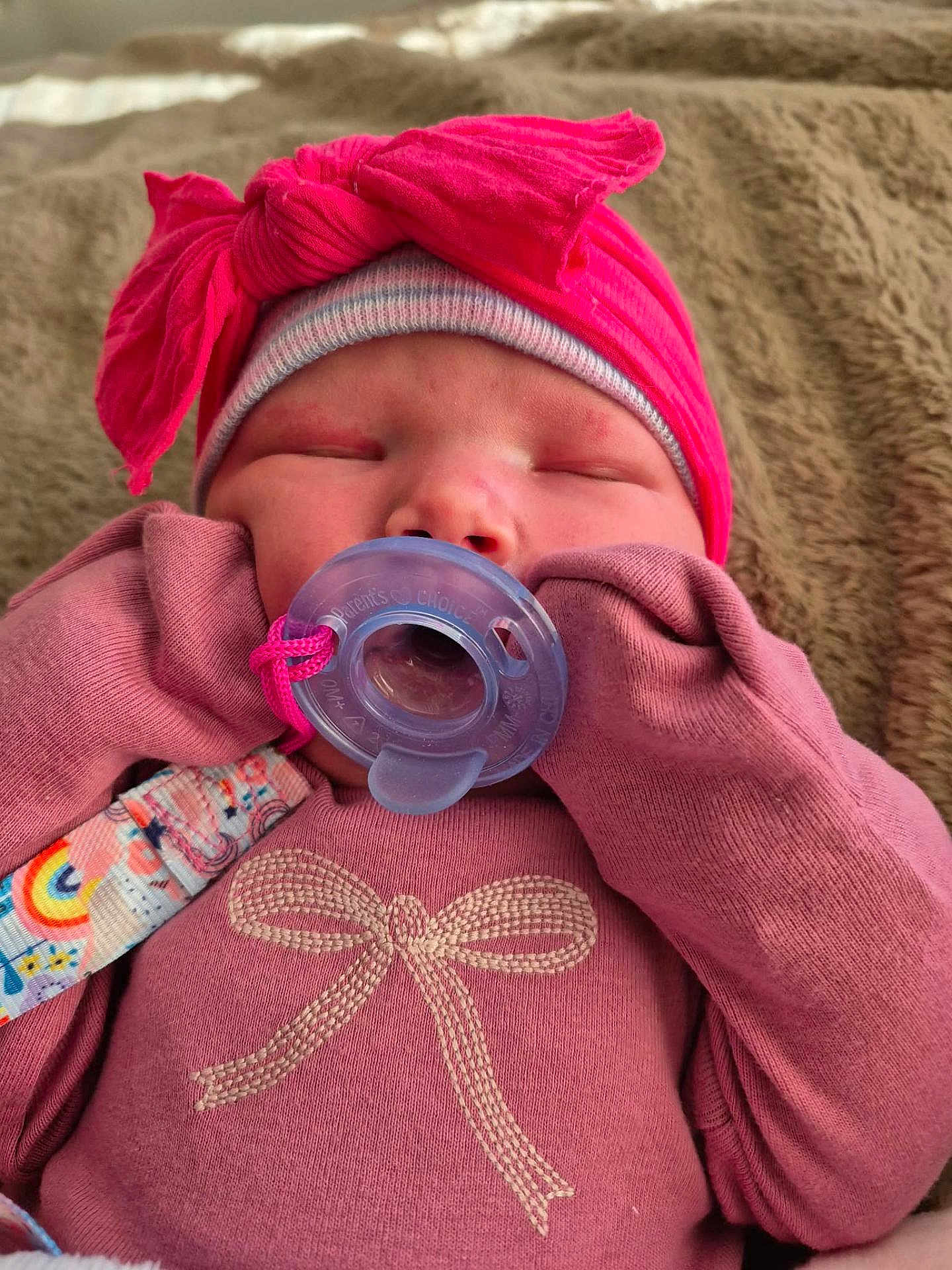 Nevaeh Mccormick is registered to the contest to win money with this photo: baby, pacifier, pink_clothing, hat, bow, sleeping, infant, gloves, blanket, closeup, cute, child, face, apparel, newborn, soft_texture, indoors, resting, baby_girl, cozy