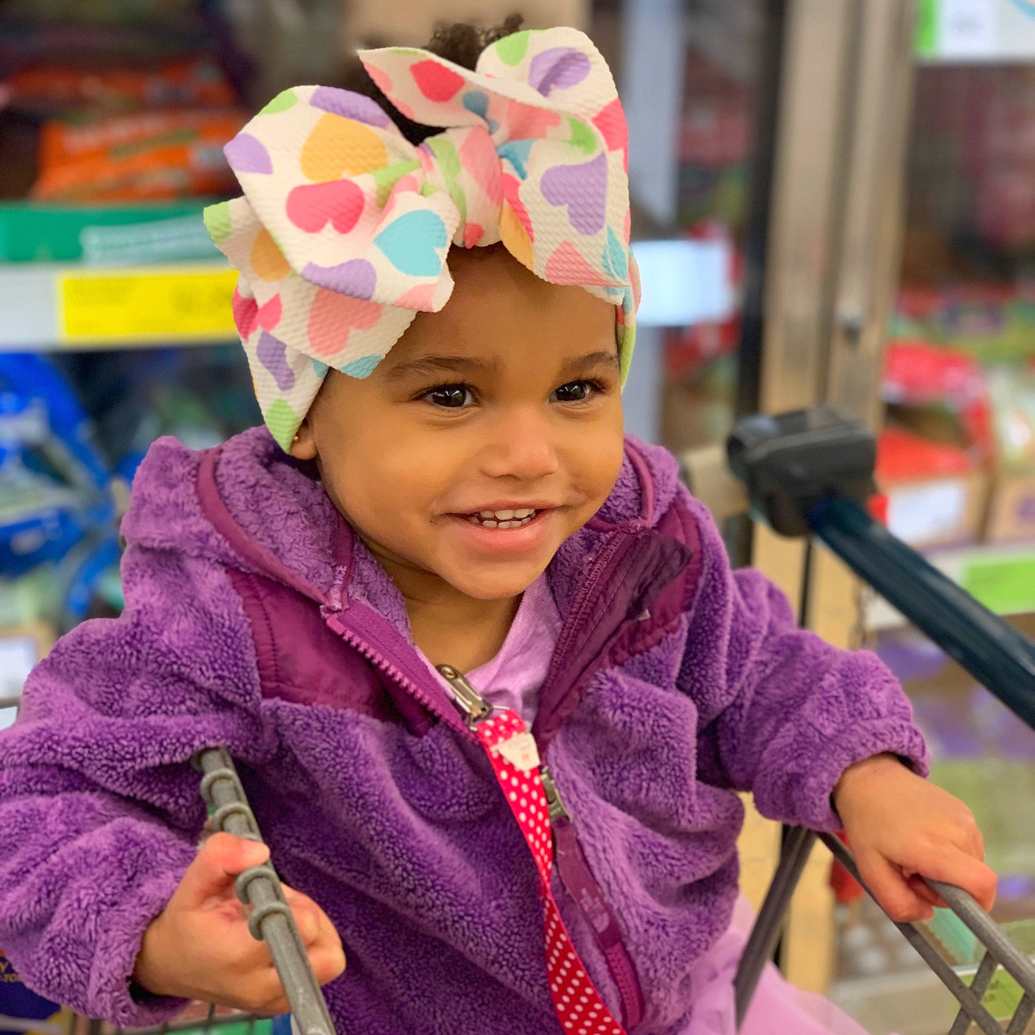 Lina is registered to the contest to win money with this photo: automotive_wheel_system, child, ear, fun, happy, headgear, headwear, joy, person, play, purple, smile, toddler, wheel