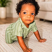 Elijah joined the competition — help win amazing prizes! toddler, child, crawling, curly_hair, green_clothing, carpet, indoor, home_interior, plant, couch, curious, portrait, person, baby, floor, young_child, cute, expression, skin, furniture
