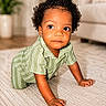 toddler, child, crawling, curly_hair, green_clothing, carpet, indoor, home_interior, plant, couch, curious, portrait, person, baby, floor, young_child, cute, expression, skin, furniture
