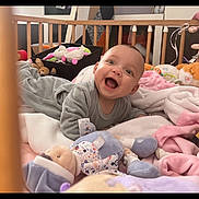 Malyha a rejoint le concours — aidez-le/la à gagner de superbes lots ! baby, crib, blanket, soft_toys, smiling, happy, indoor, child, tummy_time, wooden_crib, cute, infant, cozy, playtime, colorful, comfort, portrait, young_child, sleeping_area, home