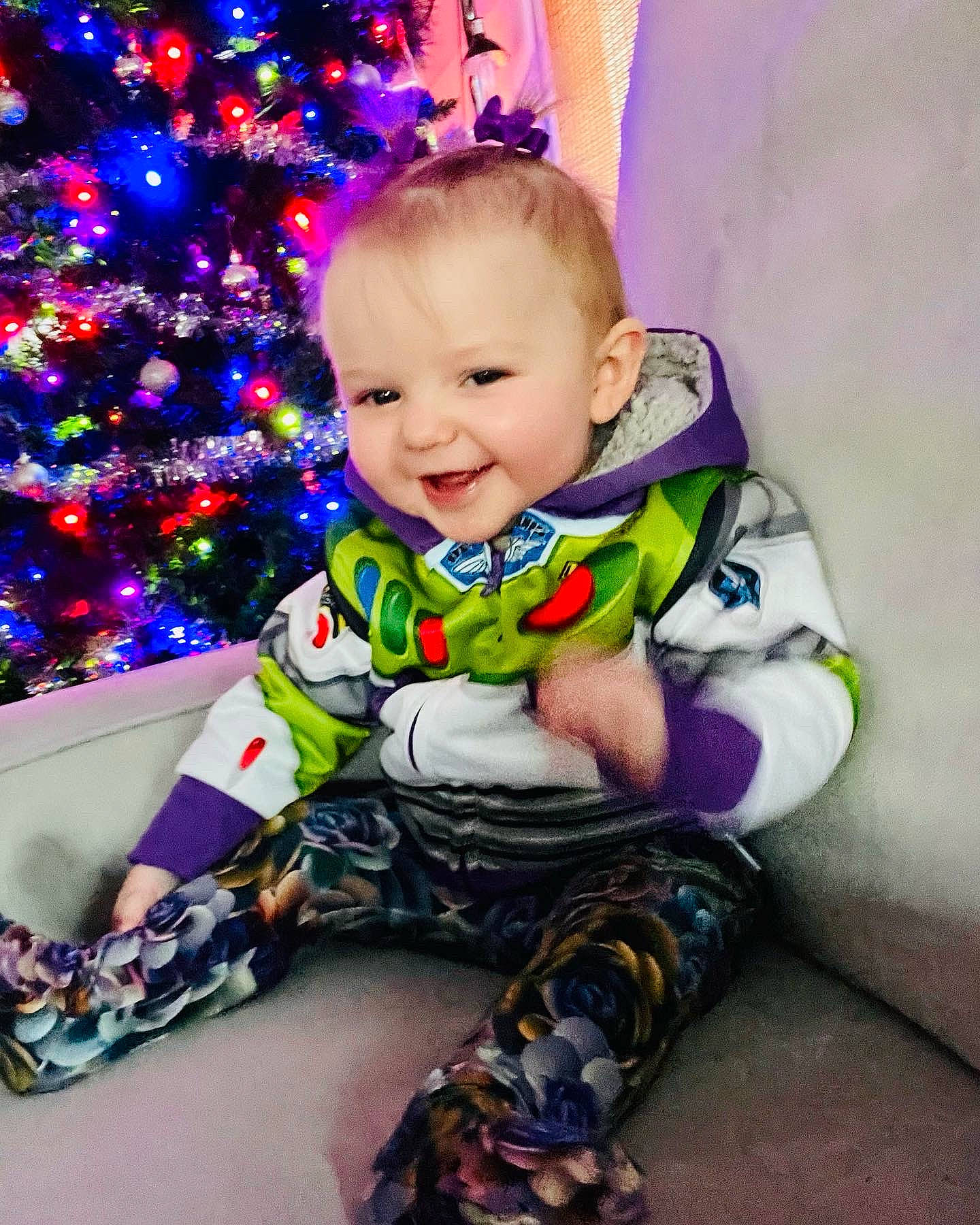 Aimee joined the competition — help win amazing prizes! baby, baby_toddler_clothing, christmas_ornament, christmas_tree, dress, event, eye, happy, human_body, iris, joy, leg, pattern, person, pink, purple, sitting, sleeve, smile, sock
