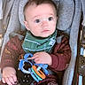 Archer is registered to the contest to win money with this photo: baby, infant, child, stroller, portrait, sitting, wide_eyed, face, eyes, clothing, bib, coat, toy, teether, harness, blanket, outdoor, transportation, close_up, photography