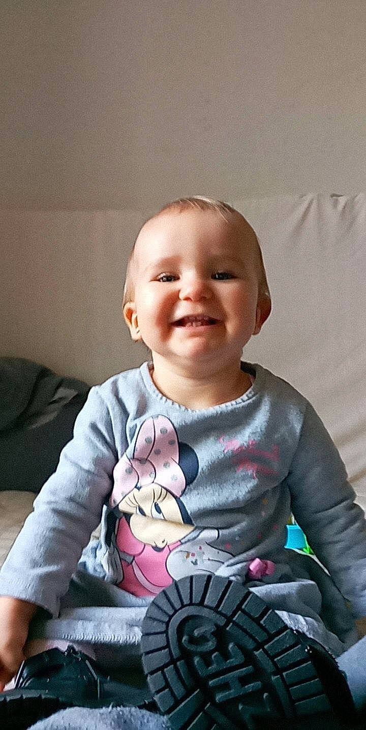 Julianna participe au concours pour gagner de l'argent avec cette photo : arm, baby, baby_toddler_clothing, cheek, child, couch, eye, fun, gadget, happy, head, human_body, iris, joy, magenta, person, sitting, skin, sleeve, smile