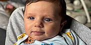 Luca joined the competition — help win amazing prizes! baby, infant, blue_eyes, onesie, animal_print, smiling, face, skin, hair, arm, blanket, indoors, baby_gear, blurred_background, comfort, cute, child, person, portrait, candid