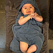Valentina a rejoint le concours — aidez-le/la à gagner de superbes lots ! baby, smiling, towel, hood, blanket, infant, cute, happy, skin, feet, hands, lying_down, indoors, child, person, soft, cozy, expression, portrait, warm
