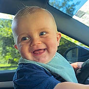 Roman joined the competition — help win amazing prizes! baby, child, smiling, happy, blue_eyes, bib, short_hair, indoor, car_interior, steering_wheel, sunlight, daylight, window, seat, clothing, playful, portrait, face, arm, person