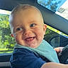 baby, child, smiling, happy, blue_eyes, bib, short_hair, indoor, car_interior, steering_wheel, sunlight, daylight, window, seat, clothing, playful, portrait, face, arm, person