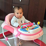 Maelle a rejoint le concours — aidez-le/la à gagner de superbes lots ! baby, child, walker, toy, pink, tablet, floor, tile, cabinet, furniture, indoor, person, clothing, socks, face, expression, hands, seat, curious, serious