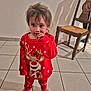 barefoot, child, christmas, curly_hair, cute, expression, face, floor, hand, indoor, pajamas, person, red_clothing, reindeer, shadow, standing, tile_floor, toddler, wall, wooden_chair