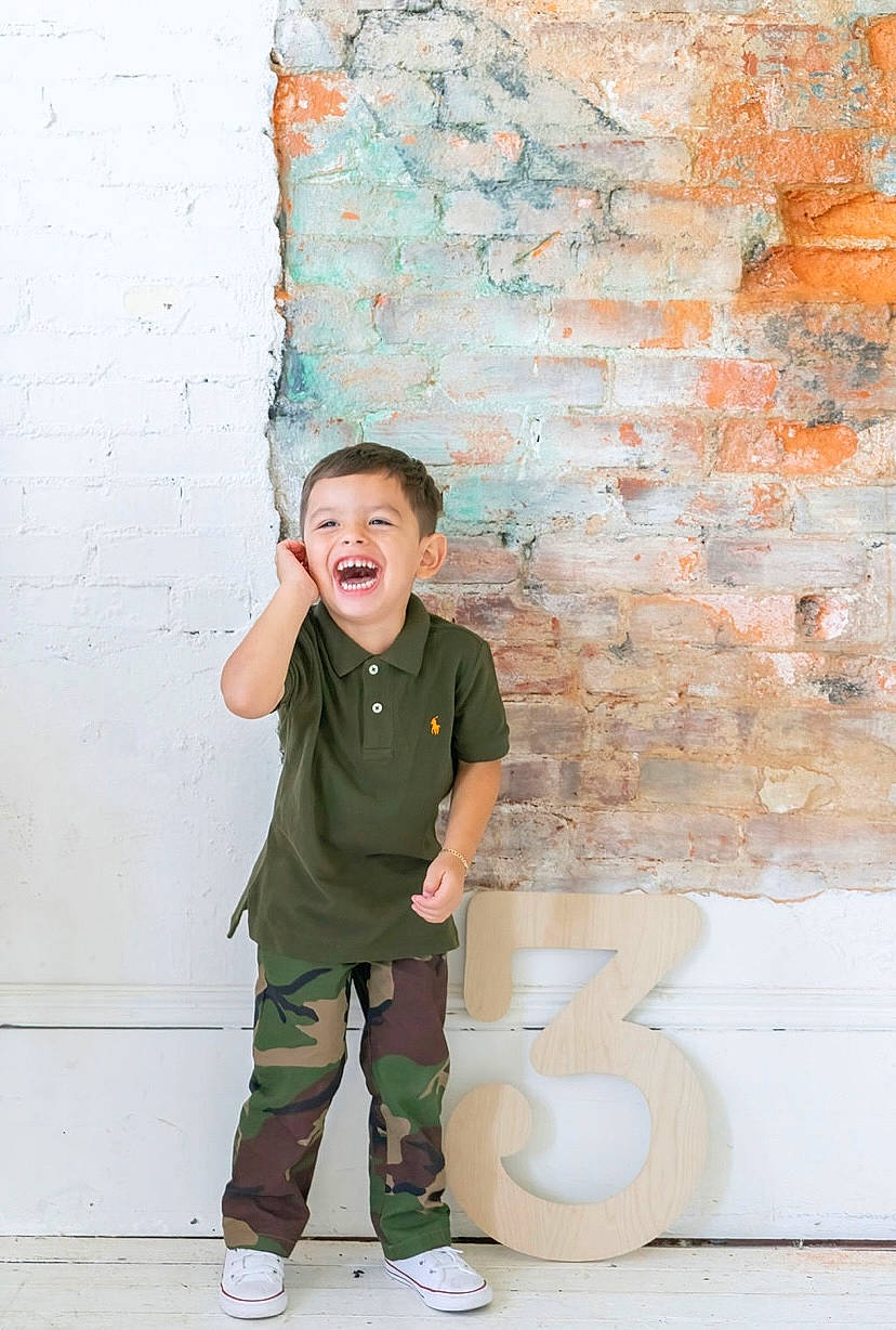 Leonardo is registered to the contest to win money with this photo: art, brick, brickwork, child, concrete, fun, happy, line, paint, person, plaster, room, sitting, smile, standing, t_shirt, tints_and_shades, toddler, visual_arts, wall