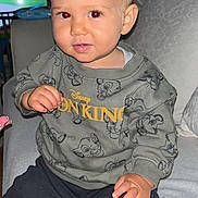 Aylan a rejoint le concours — aidez-le/la à gagner de superbes lots ! toddler, child, sitting, sweatshirt, lion_king, nike, sock, couch, indoors, red_eye, curious, short_hair, clothing, person, home, blanket, smile, face, television, furniture