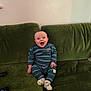 William joined the competition — help win amazing prizes! baby, smiling, green_couch, striped_clothing, sitting, happy, indoor, child, pajamas, footwear, person, couch, furniture, living_room, cute, infant, portrait, cozy, home, relaxed