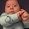 baby, infant, child, portrait, lying_down, wide_eyed, hands, clasped_hands, onesie, zipper, blanket, pillow, indoor, close_up, face, eyes, calm, cozy, photography, textile