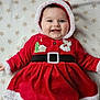 baby, child, smiling, red_clothing, hood, blanket, stars_pattern, face, happy, cute, christmas, holiday, festive, fur_trim, portrait, infant, lying_down, indoors, cozy, warm