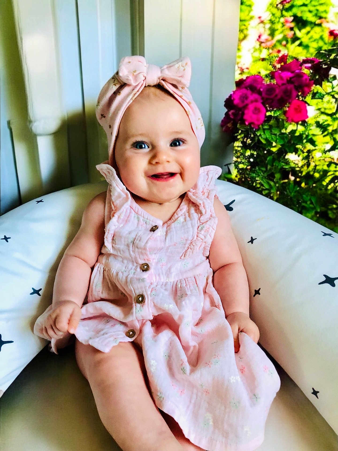 élia participe au concours pour gagner de l'argent avec cette photo : baby, child, smiling, pink_dress, headband, bow, cushion, indoor, flowers, greenery, happy, portrait, sitting, blue_eyes, cute, infant, soft_lighting, person, skin, cheerful