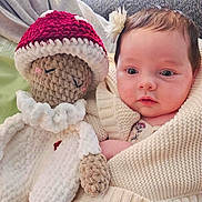 Elowyn joined the competition — help win amazing prizes! baby, infant, blanket, crocheted_doll, knitwear, toy, child, portrait, cute, indoors, soft_texture, warm_colors, holding, face, head, hand, expression, young, cozy, wrapped