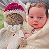 baby, infant, blanket, crocheted_doll, knitwear, toy, child, portrait, cute, indoors, soft_texture, warm_colors, holding, face, head, hand, expression, young, cozy, wrapped