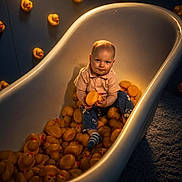 Ellijah is registered to the contest to win money with this photo: baby, bathtub, rubber_duck, child, indoor, toy, playful, cute, infant, clothing, socks, floor, carpet, portrait, lighting, expression, sitting, yellow, white, room