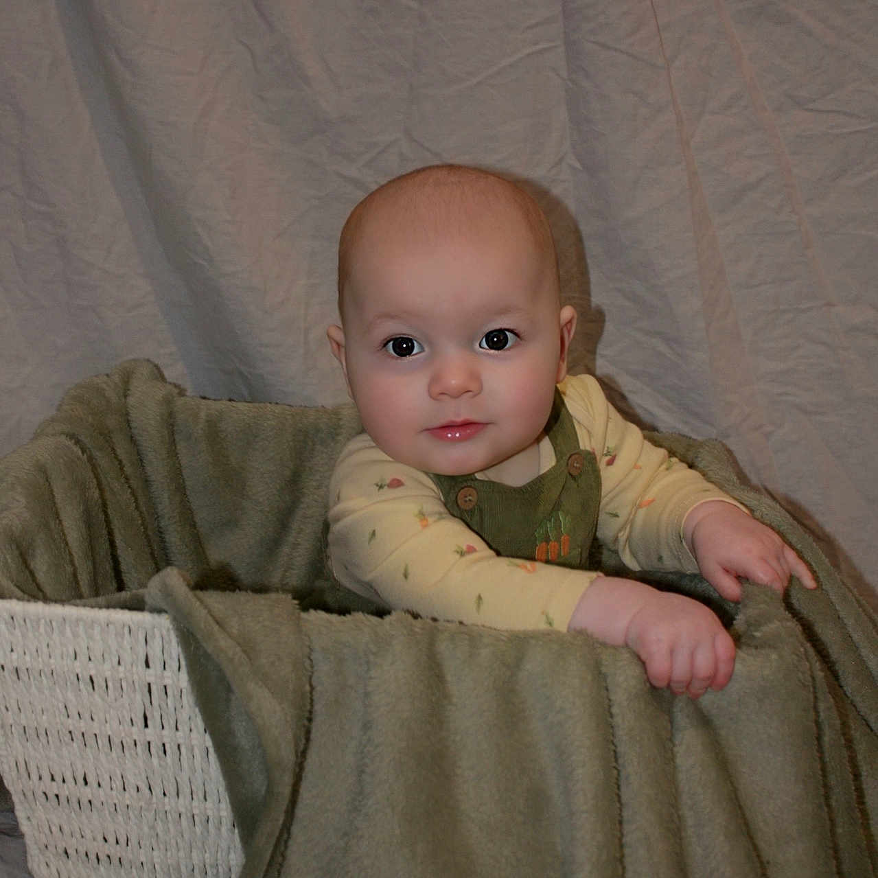 Ellijah is registered to the contest to win money with this photo: baby, basket, blanket, child, clothing, cozy, cute, fabric, face, hand, indoors, infant, one_person, person, portrait, sitting, soft_texture, toddler, warm, wrinkled_background