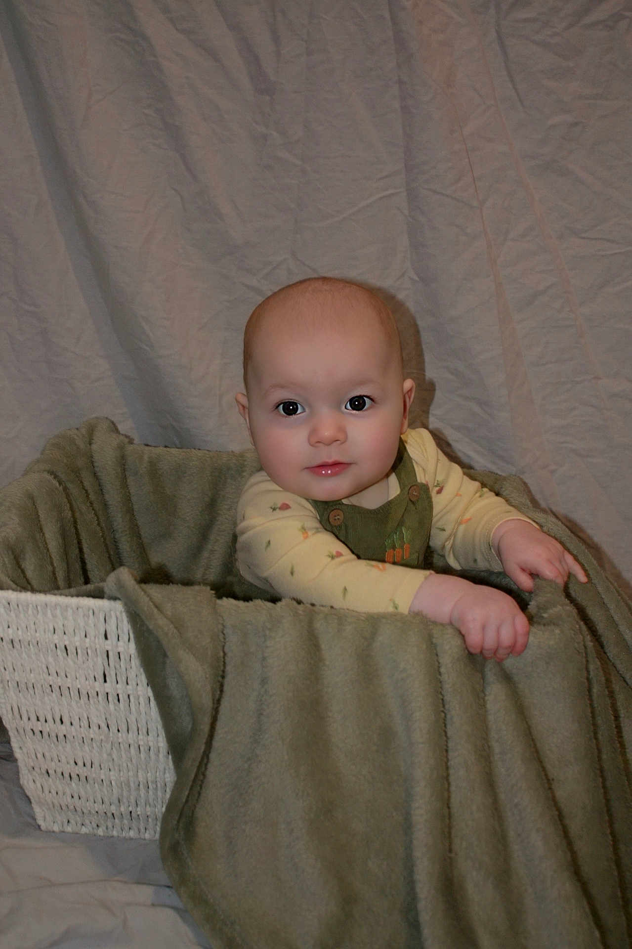 Ellijah is registered to the contest to win money with this photo: baby, basket, blanket, child, clothing, fabric, face, hand, indoors, infant, one_person, person, portrait, sitting, soft_texture, toddler, wrinkled_background, cute, cozy, warm