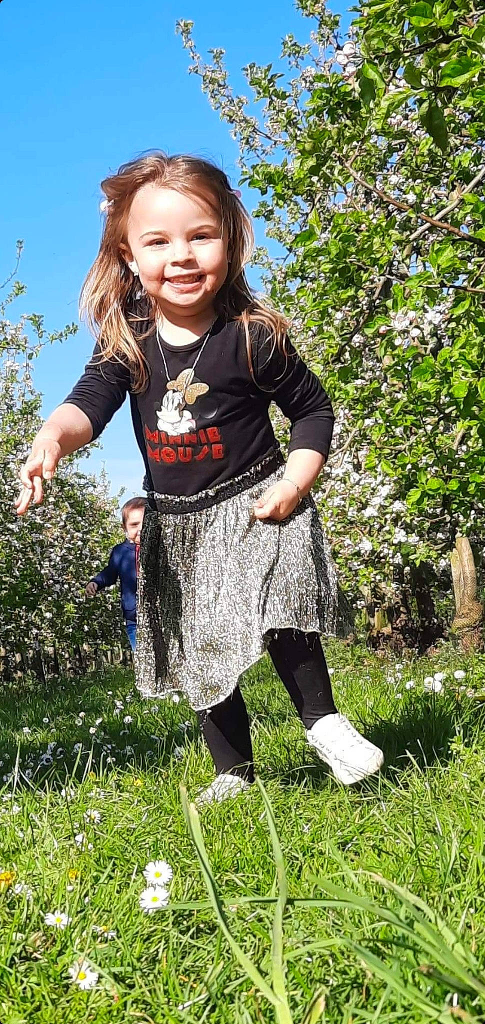 Mila participe au concours pour gagner de l'argent avec cette photo : baby_toddler_clothing, blue, electric_blue, fun, grass, grassland, happy, human_leg, joy, leisure, pattern, people_in_nature, person, plant, sky, sleeve, smile, street_fashion, t_shirt, toddler