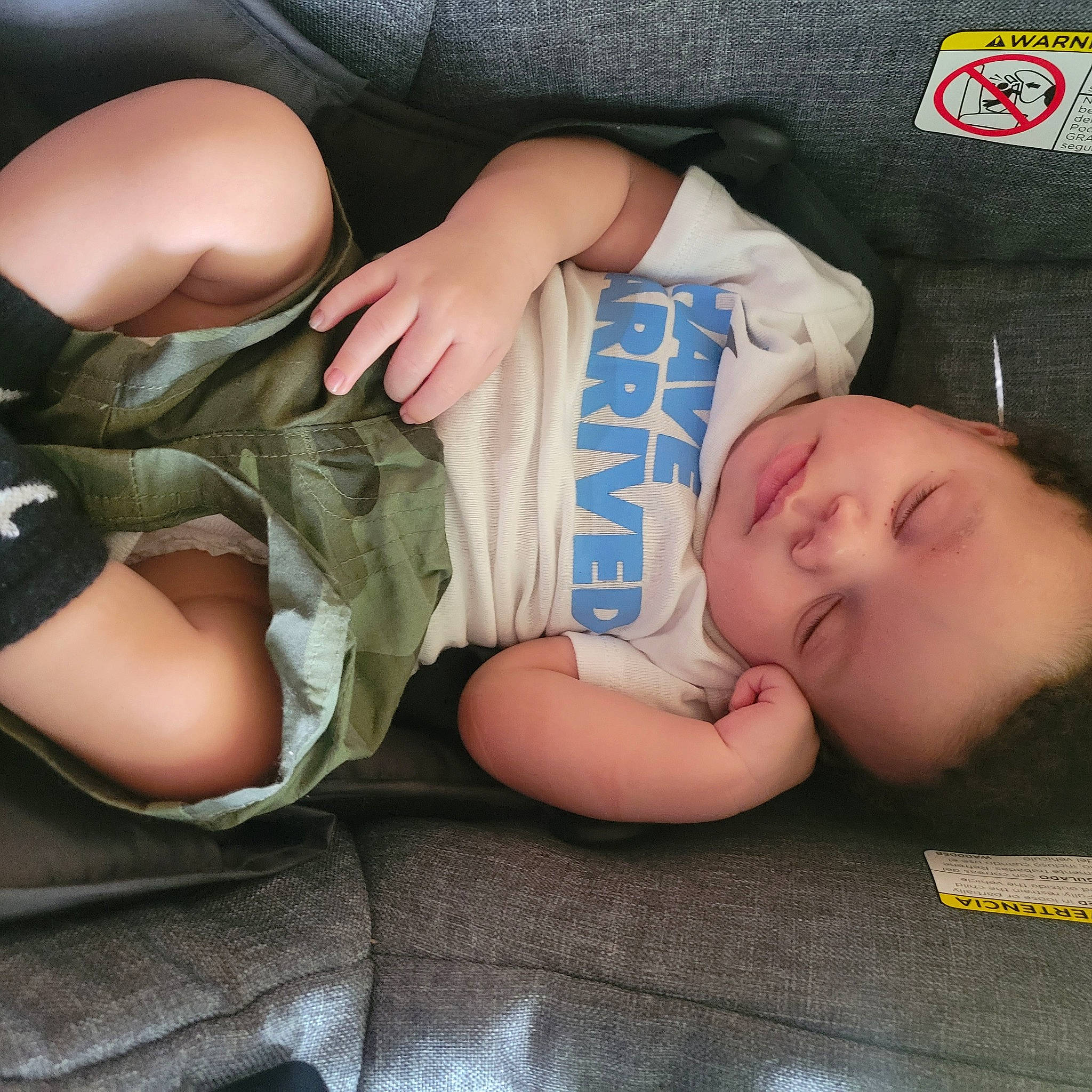 Ayden is registered to the contest to win money with this photo: baby, baby_sleeping, baby_toddler_clothing, camouflage, cheek, child, comfort, cool, elbow, facial_expression, finger, gesture, hand, human_leg, mouth, person, product, skin, sleeve, thigh