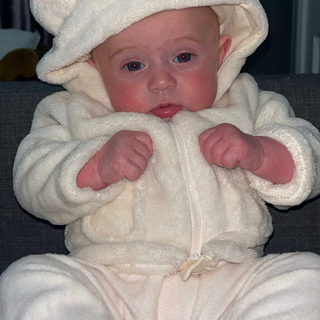 Sarahlouise Jasmine is registered to the contest to win money with this photo: baby, bodypart, bonnet, cap, clothing, couch, face, finger, hand, hat, head, hood, hoodie, knitwear, newborn, person, photography, portrait, sweater, sweatshirt