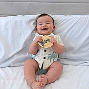 Leo joined the competition — help win amazing prizes! baby, smiling, infant, bed, white_bedding, wooden_sign, five_months, shirt, shorts, happy, cute, child, portrait, indoors, person, sitting, skin, head, hands, feet