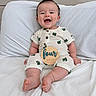 Leo joined the competition — help win amazing prizes! baby, smiling, infant, white_bed, cactus_pattern, outfit, wooden_sign, four_months, happy, cute, sitting, milestone, child, portrait, indoors, person, face, foot, hand, soft_lighting