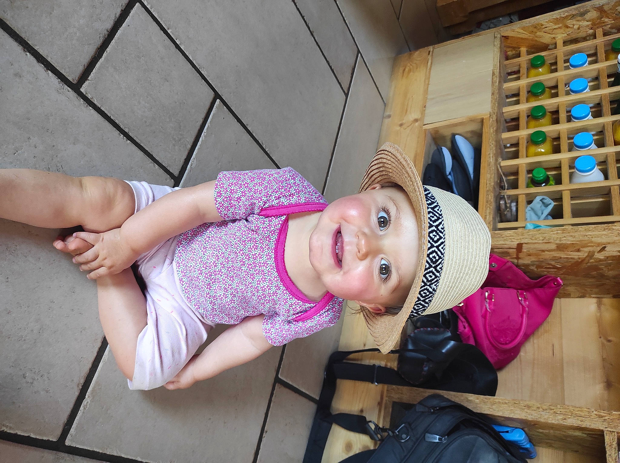 Laly participe au concours pour gagner de l'argent avec cette photo : baby, baby_toddler_clothing, backpack, child, dress, elbow, happy, hat, headwear, human_leg, joy, knee, leisure, magenta, pattern, person, pink, sandal, shelf, smile