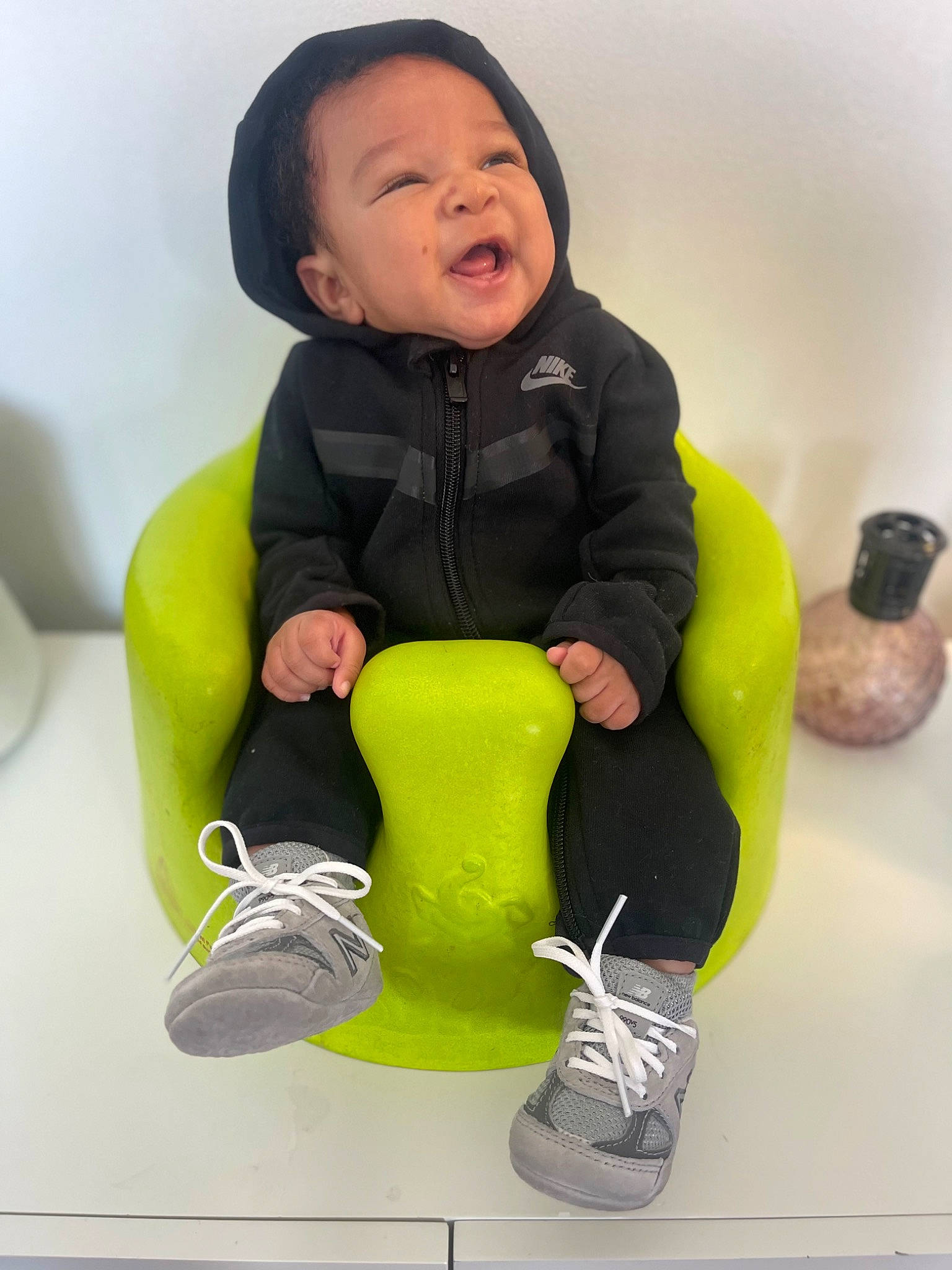 Devonte joined the competition — help win amazing prizes! baby, baby_toddler_clothing, comfort, face, finger, fun, gesture, glove, happy, human_leg, jacket, knee, person, shoe, sitting, sleeve, smile, sneakers, standing, thigh