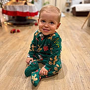 Sacha a rejoint le concours — aidez-le/la à gagner de superbes lots ! toddler, child, smiling, pajamas, gingerbread_men, holiday, christmas, indoors, wooden_floor, flooring, sitting, cute, festive, decorations, blurred_background, warm_lighting, person, young_child, portrait, happy