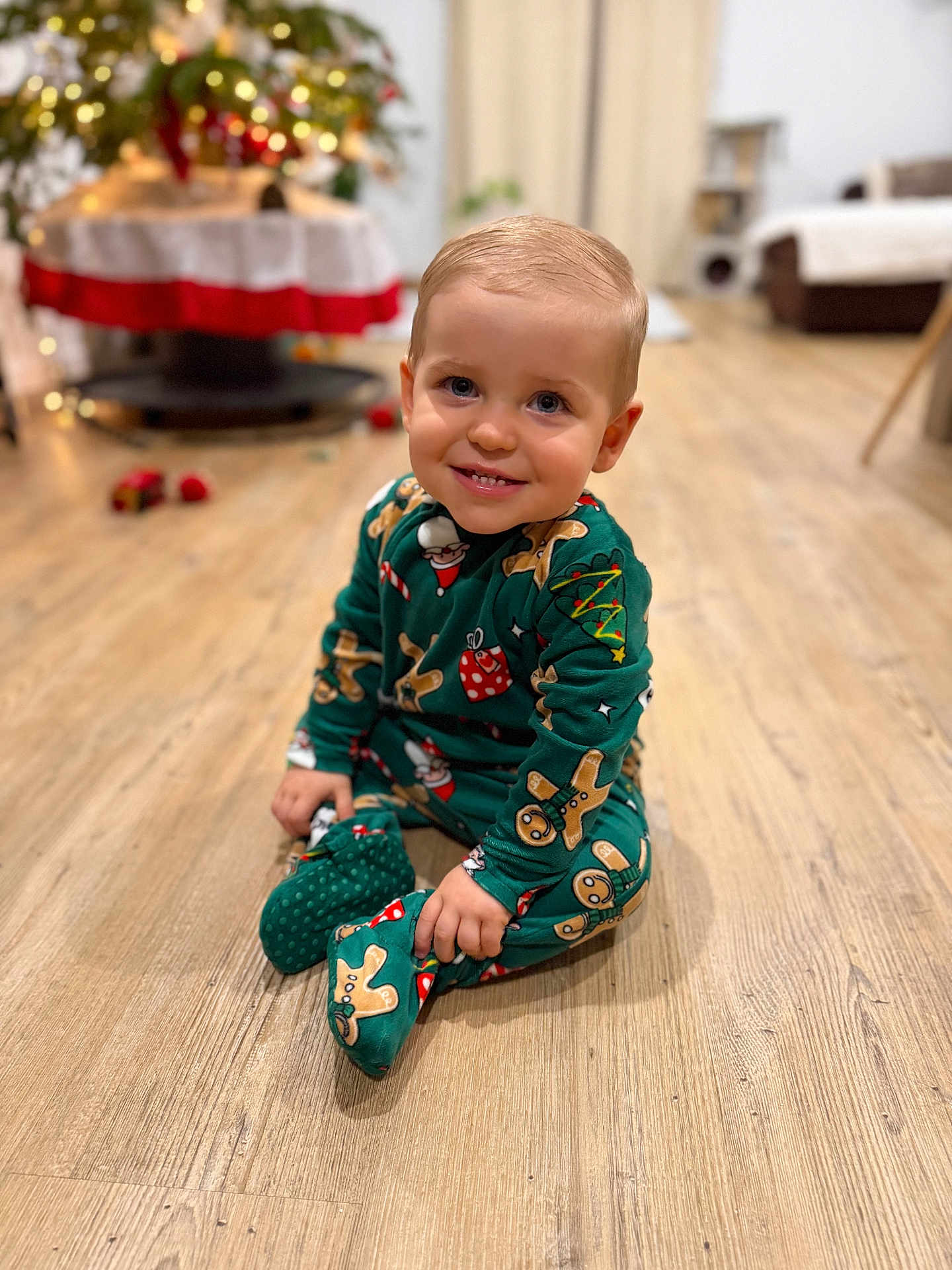 Sacha a rejoint le concours — aidez-le/la à gagner de superbes lots ! toddler, child, smiling, pajamas, gingerbread_men, holiday, christmas, indoors, wooden_floor, flooring, sitting, cute, festive, decorations, blurred_background, warm_lighting, person, young_child, portrait, happy