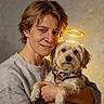 woman, person, dog, pet, portrait, painting, digital_art, halo, fluffy, small_dog, harness, colorful, cuddling, smiling, face, shoulders, indoor, warm_lighting, golden_light, signature
