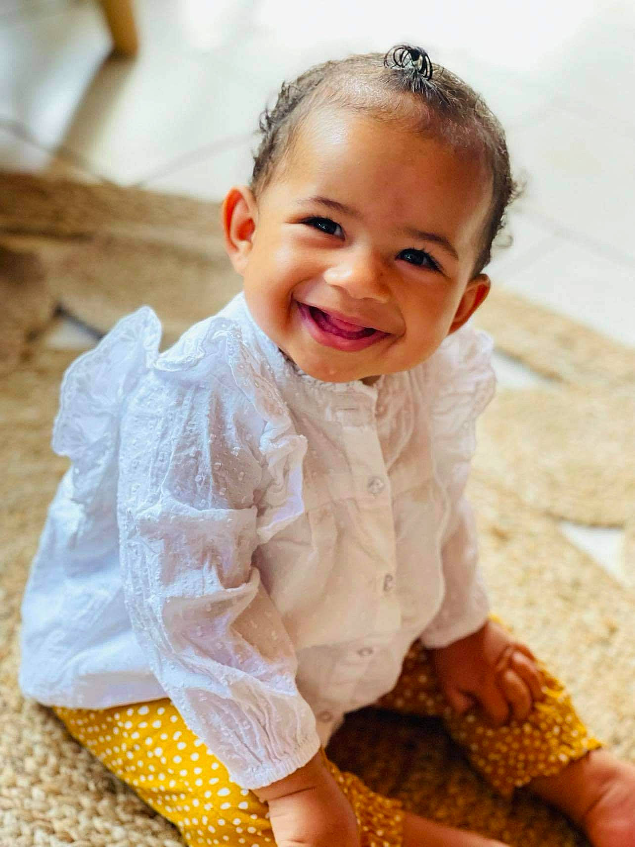 Alyzia a rejoint le concours — aidez-le/la à gagner de superbes lots ! baby, baby_toddler_clothing, cheek, child, dress, finger, floor, flooring, gesture, happy, head, joy, neck, outerwear, person, skin, sleeve, smile, textile, toddler