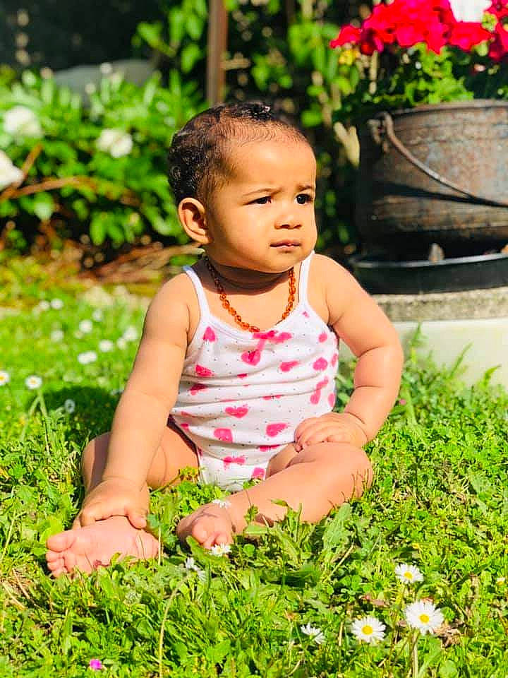 Alyzia participe au concours pour gagner de l'argent avec cette photo : baby, baby_toddler_clothing, botany, dress, eye, facial_expression, flower, flowerpot, grass, green, hairstyle, happy, leaf, nature, people_in_nature, person, pink, plant, skin, sunlight