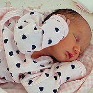 Bonnie is registered to the contest to win money with this photo: newborn, baby, sleeping, blanket, pink, onesie, heart_pattern, infant, peaceful, cozy, soft, cute, child, face, skin, head, hand, bed, fabric, closeup