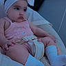 Ailannys is registered to the contest to win money with this photo: baby, blanket, bow, car_seat, child, close_up, clothing, cozy, eyes, face, headband, indoors, infant, pink_outfit, portrait, seatbelt, serious_expression, sitting, vehicle, white_socks