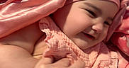 Ailannys is registered to the contest to win money with this photo: adult_hand, baby, blanket, child, closeup, clothing, cozy, cuddling, eyes, face, hand, happy, headwrap, indoors, infant, mouth, pink, portrait, smiling, soft_lighting